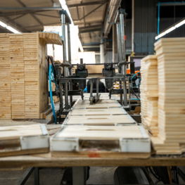 industrial-woodworking-facility-with-stacks-wooden-planks-pallets-organized-processing-bright-industrial-lighting-showcasing-busy-organized-work-environment.jpg